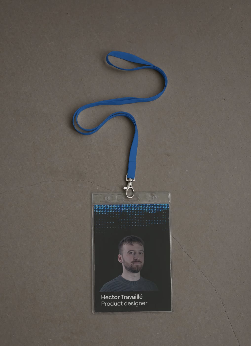 Badge de salon Sahar porté sur cordon bleu, posé sur du béton : trame de points cobalt en tête, portrait et nom en pied.